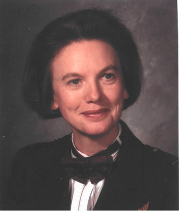 Portrait de Christine en uniforme, posant avec un léger sourire, fond neutre.